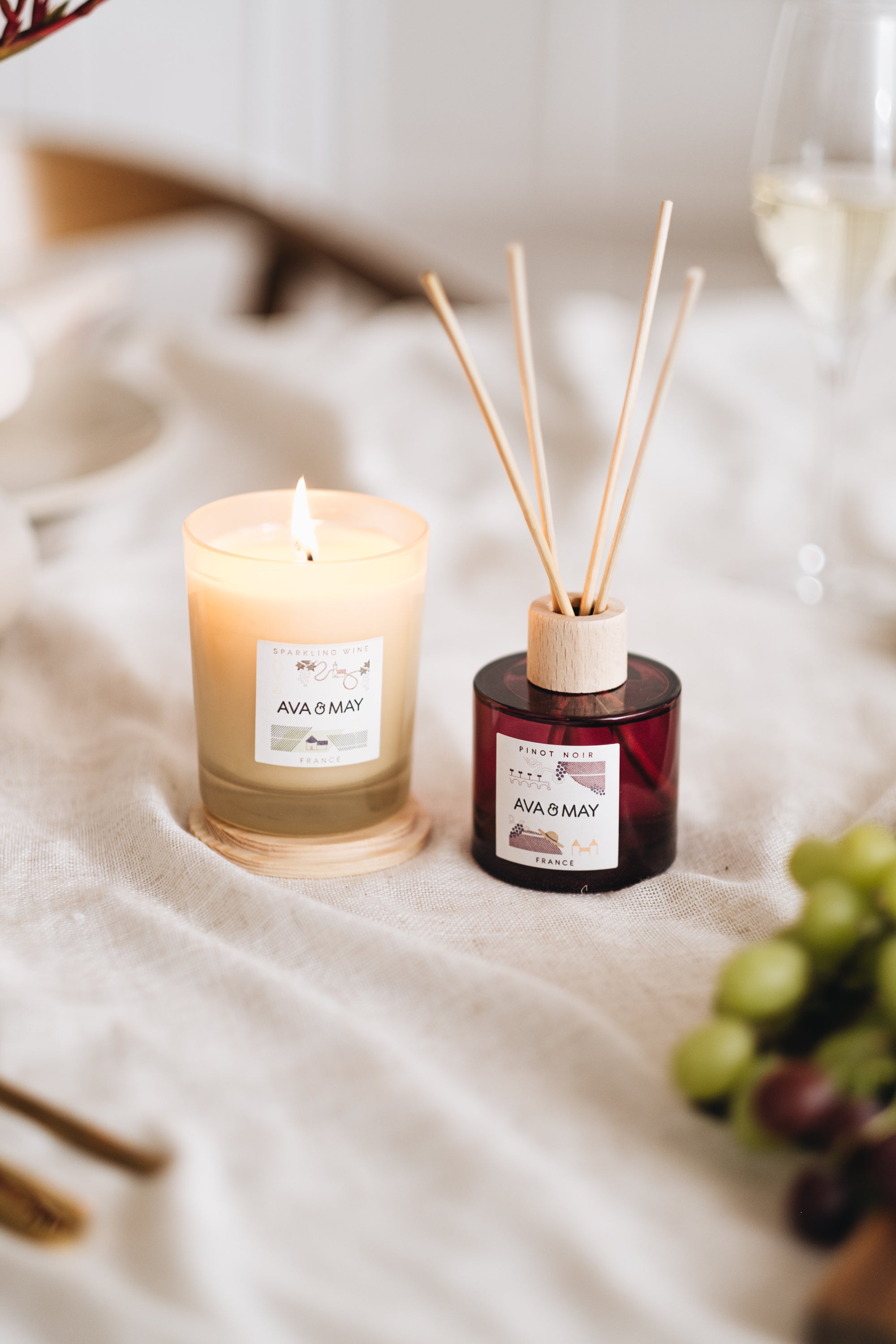 Soft Sip Set bestehend aus Duftkerze und Duftstäbchen in beigem und rotem Glas, von AVA & MAY