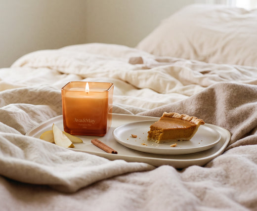 Die 220 g Pumpkin Pie Kerze von Ava&May, die auf einem Tablett brennt, das auf einem Bett aus einem Stück Kuchen mit Kürbiscreme, Birnen und Zimt steht