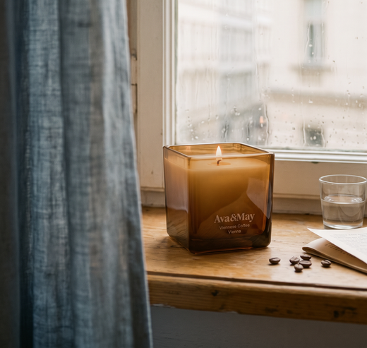 Kerze von Ava&May Viennese Coffee brennt auf der Fensterbank, während es draußen regnet